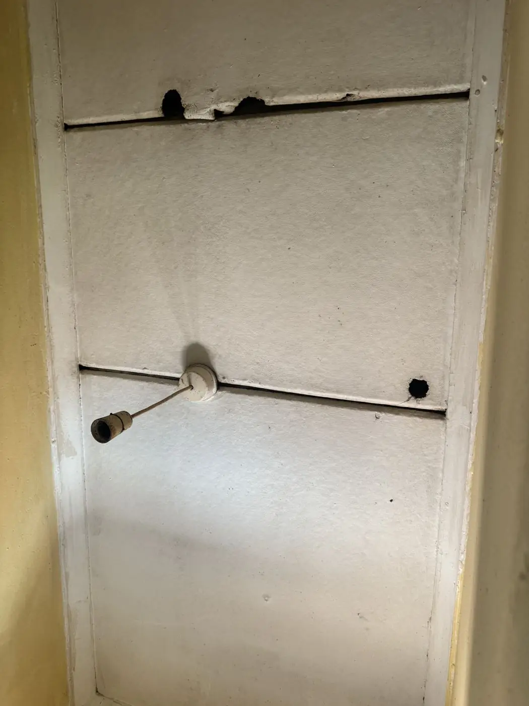 Close-up of broken panel and exposed fixing holes